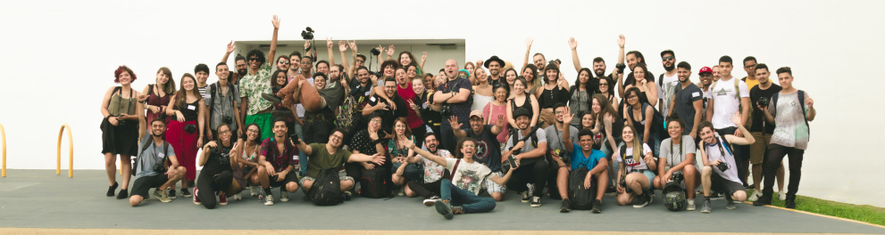 Um grupo de muitas pessoas está reunido bem feliz e posando sorridente para a foto