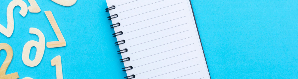 Um caderno em branco e vários números em uma superfície azul