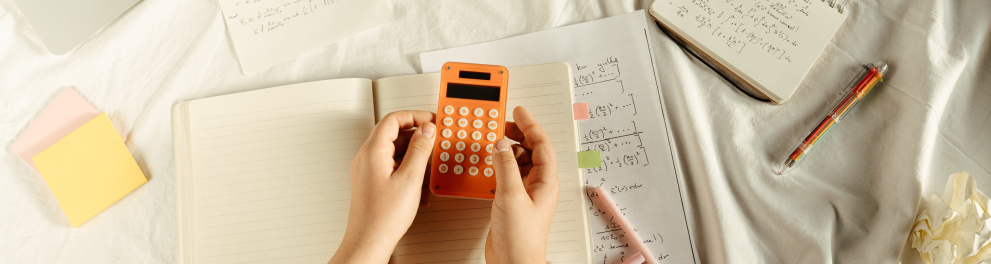 Uma pessoa com uma calculadora e cadernos