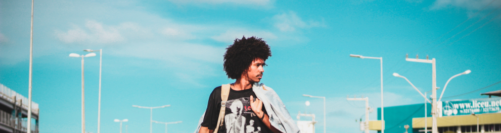 Um jovem negro andando no meio da rua