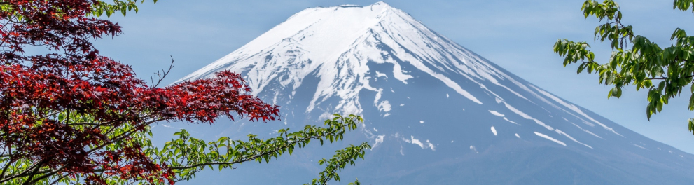 Imagem à distância do Monte Fuji, no Japão. Trata-se de uma grande montanha rochosa com neve em seu topo