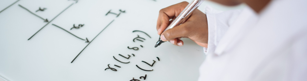 Um menino fazendo exercícios matemáticos em uma superfície branca