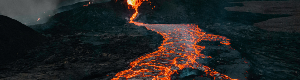 Imagem da lava de um vulcão escorrendo pelo mesmo e deixando o solo todo em chamas laranjas