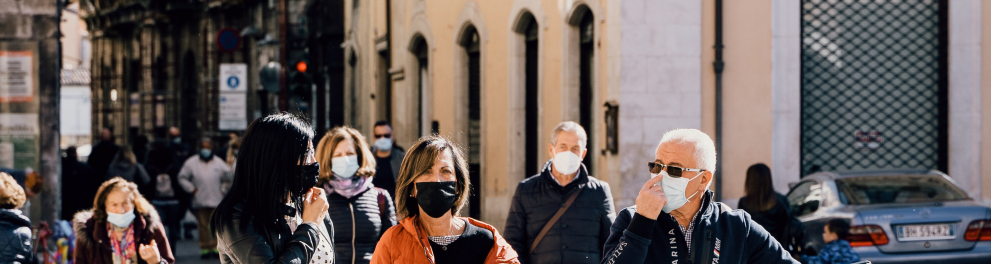 Pessoas de máscaras de prevenção à covid estão andando por uma rua