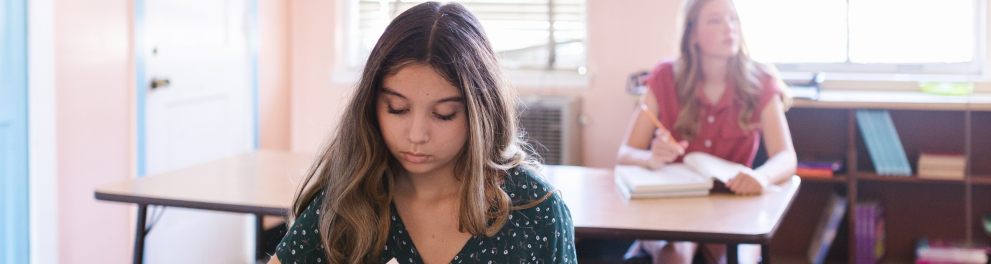 Duas adolescentes em uma sala de aula de uma escola