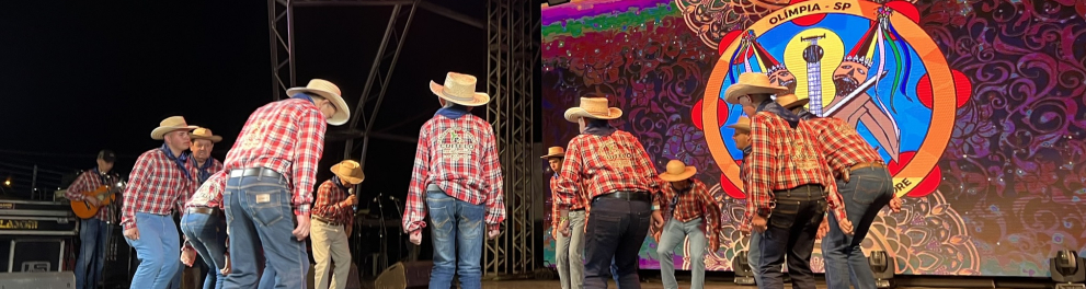 Pessoas dançam sobre um palco.