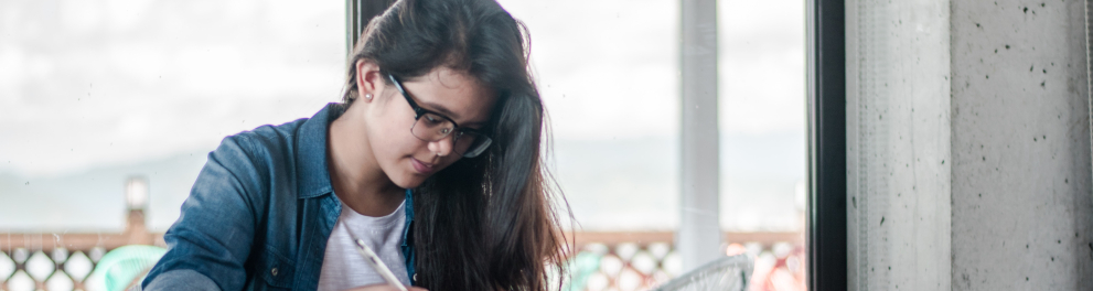 Uma jovem estudante com um livro e lapis na mão