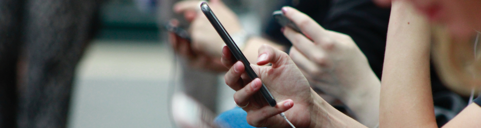 Um grupo de pessoas sentadas e mexendo em celulares
