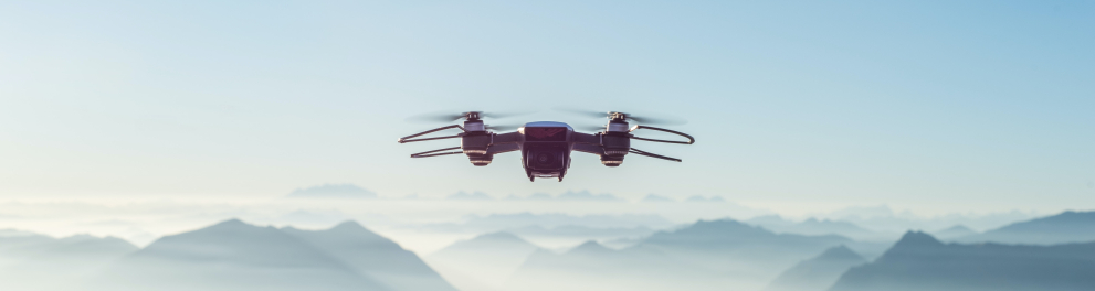 Um drone branco planando pelo céu azul
