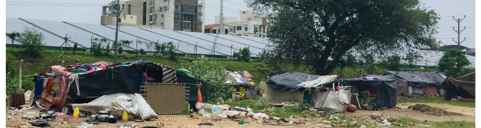 Imagem de barracos pobres em um meio urbano e, ao fundo, a imagem de edifícios. A imagem mostra um pouco da desigualdade social no mundo