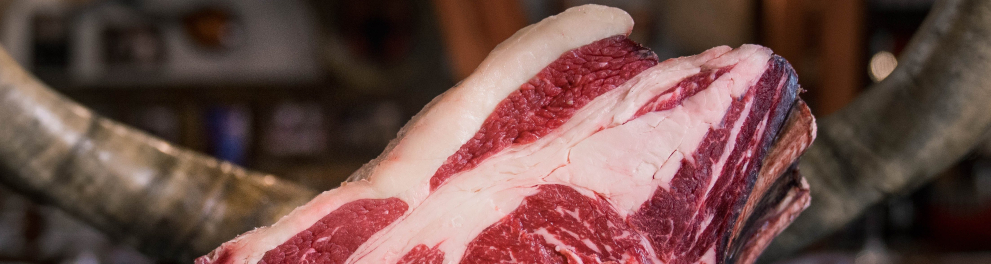 Uma enorme peça de carne vermelha crua em cima de uma bancada