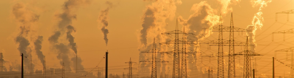 Muita fumaça saindo de dentro de usinas em um ambiente urbano