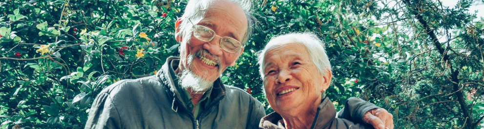 Um casal asiático de idosos está posando sorridente para quem bateu a foto