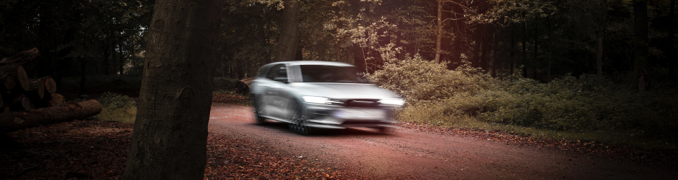 Imagem de um carro em movimento, possivelmente acima do limite de velocidade