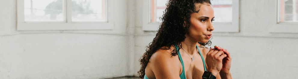 Uma mulher com roupa de academia está realizando um agachamento