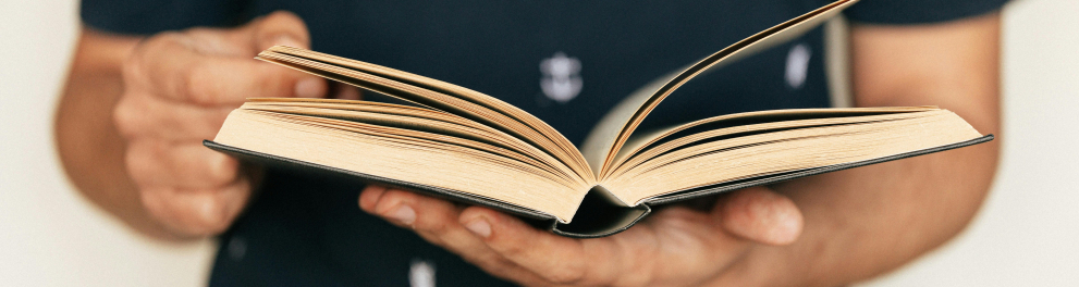 Um rapaz com um livro em suas mãos