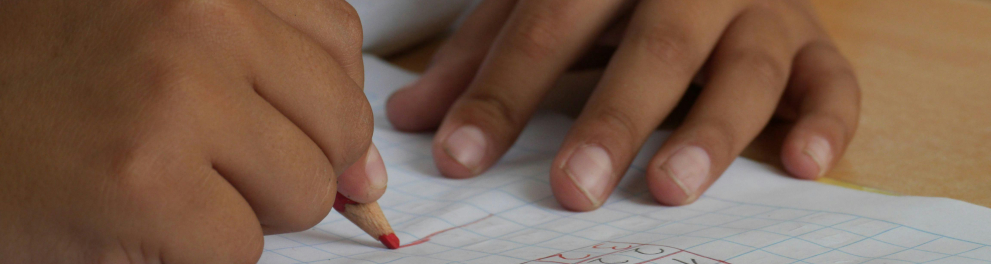 Alguém escrevendo em um caderno com um lápis