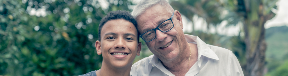 A imagem mostra um homem idoso e um jovem lado a lado