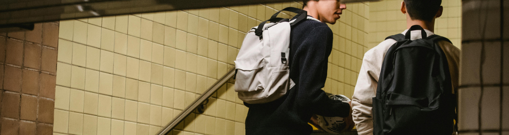 Dois jovens sobem a escada de uma estação de metrô.