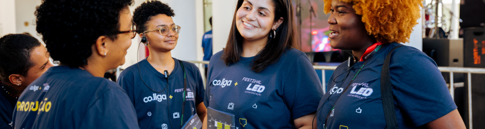 Jovens usando camisa do Festival LED e da co.liga conversam, sorrindo.