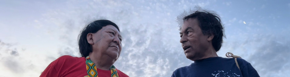 A imagem mostra Davi Kopenawa e Ailton Krenak nos bastidores do documentário "Kopenawa: sonhar a terra-floresta"