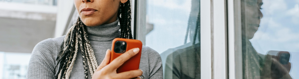 Uma mulher com o celular na mão em dúvida