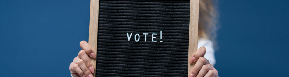 Mulher segurando placa escrito vote