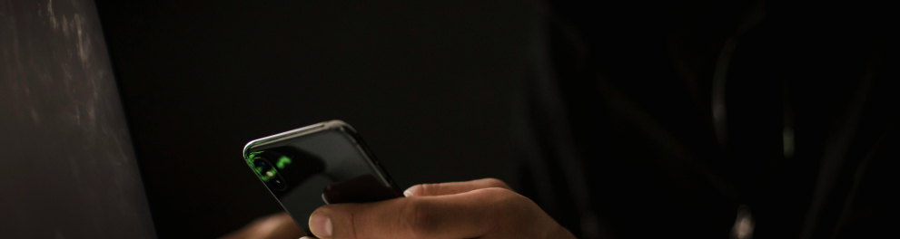 Foto de um hacker mexendo no celular