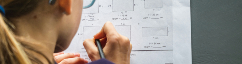 Uma menina fazendo exercícios de matemática em um papel
