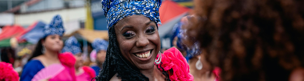 Uma mulher negra sorri em uma festividade