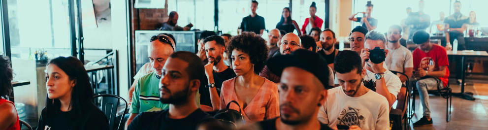 Um grupo de pessoas sentadas em cadeiras em uma sala de conferência
