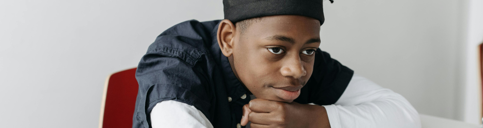 A imagem mostra uma criança negra em uma sala de aula