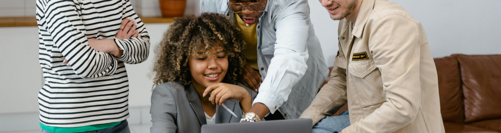 A imagem mostra um grupo de jovens em torno de um notebook