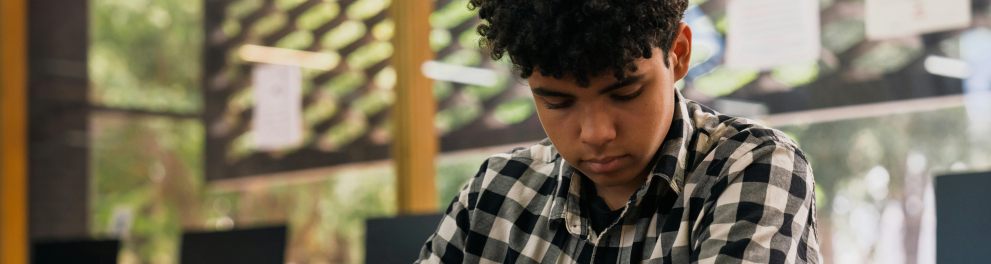 A imagem mostra um adolescente lendo um livro