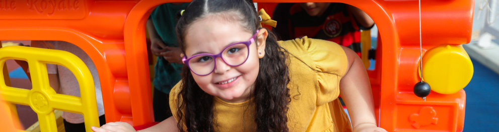 A imagem mostra uma menina brincando em um parquinho