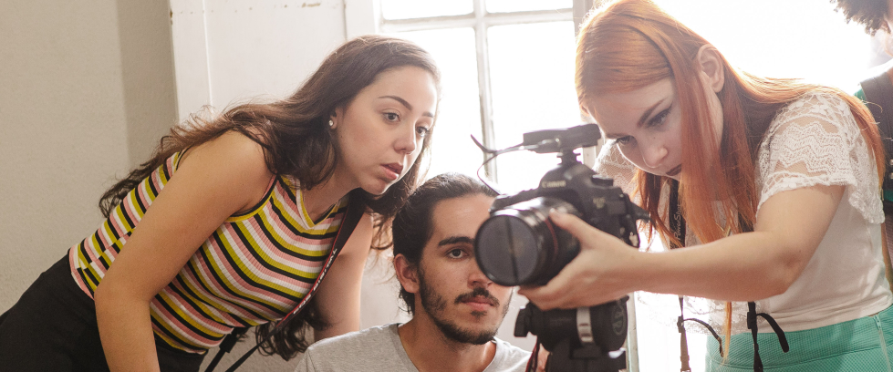 Jovens em volta de uma câmera