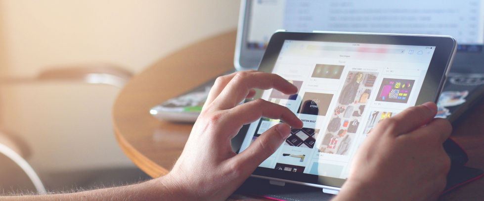 Duas mãos seguram um tablet, indicando que farão o movimento de pinça para dar zoom na imagem.