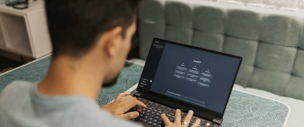 A imagem mostra um jovem rapaz usando um notebook com o chatgpt aberto