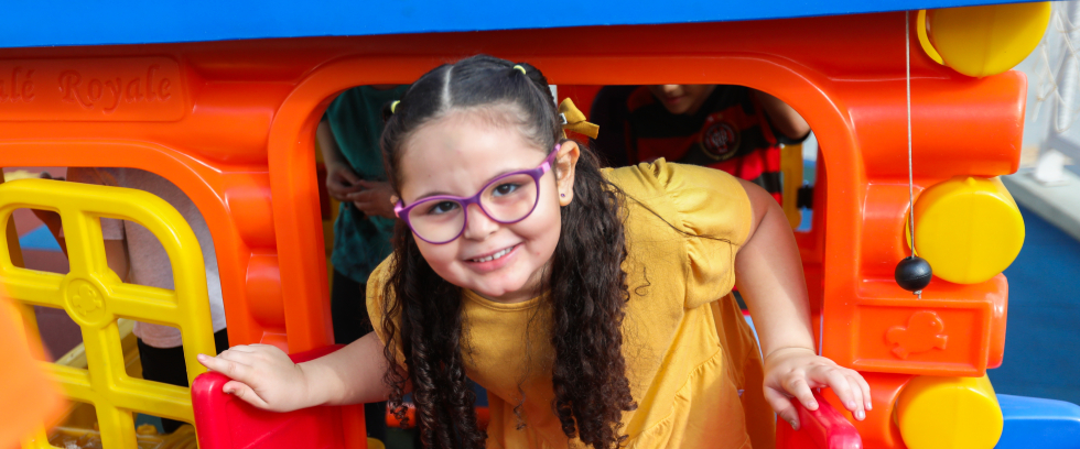 A imagem mostra uma menina brincando em um parquinho