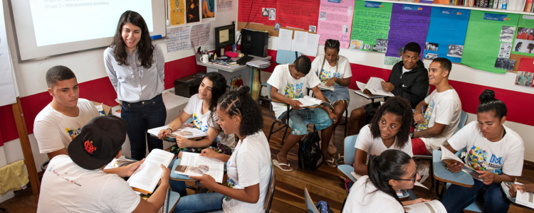 Sala de aula com estudantes e professora.