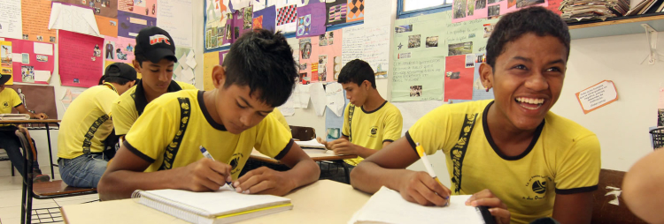 meninos em sala de aula escrevendo em seus cadernos