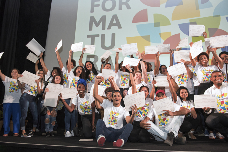 alunos da Escola da Fundação Roberto Marinho levantando os diplomas na festa de formatura