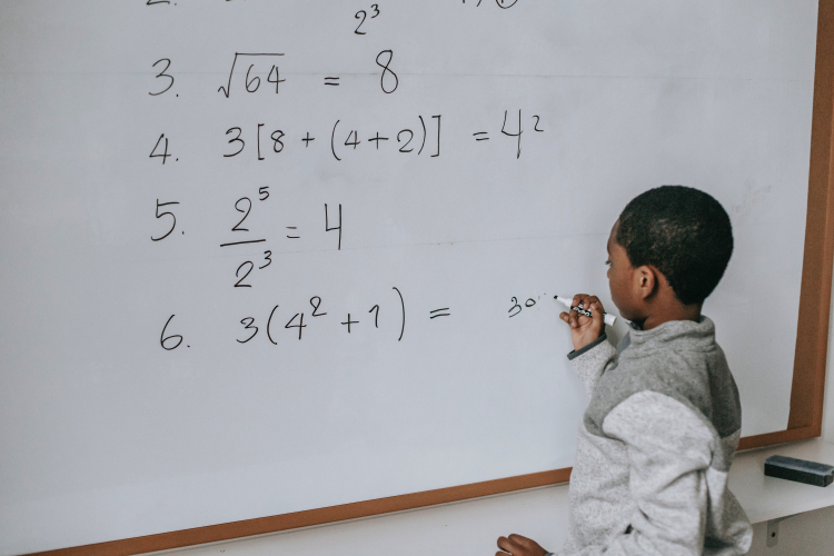 meninos negro resolvendo cálculos matemáticos na lousa