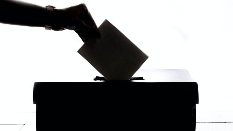 Uma pessoa colocando um papel em uma caixa