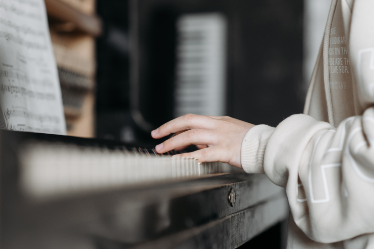 Imagem mostra uma mão tocando piano.