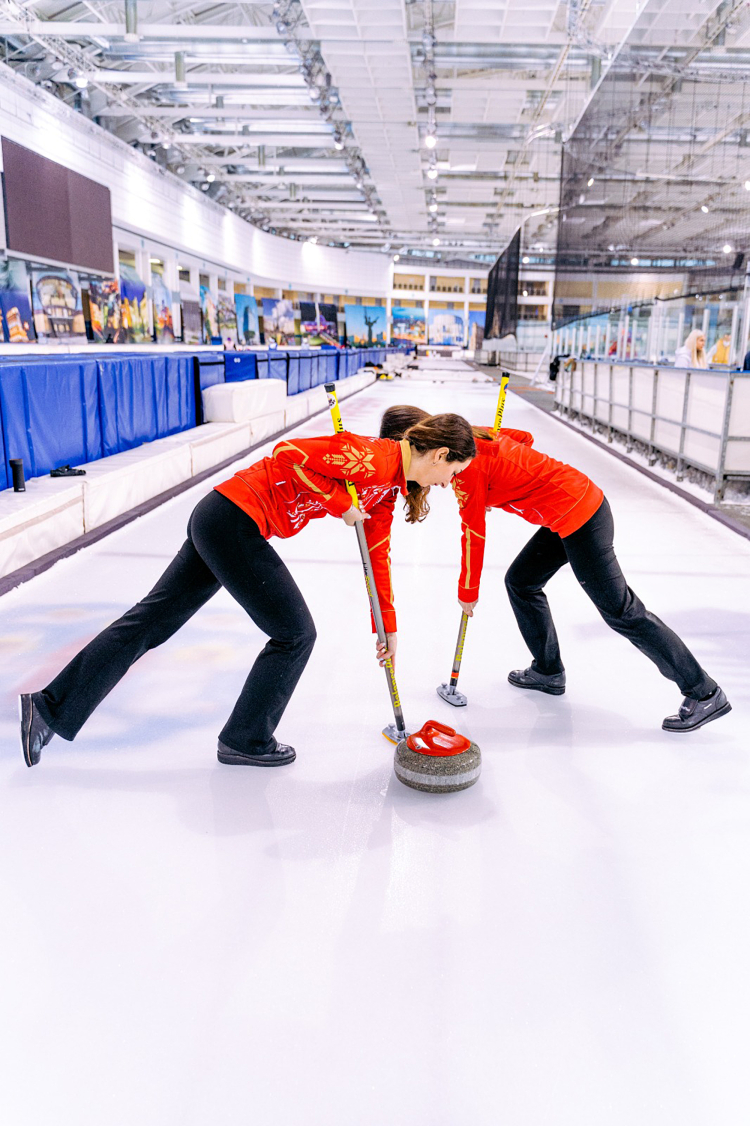 Imagem mostra duas mulheres durante a pratica do esporte curling
