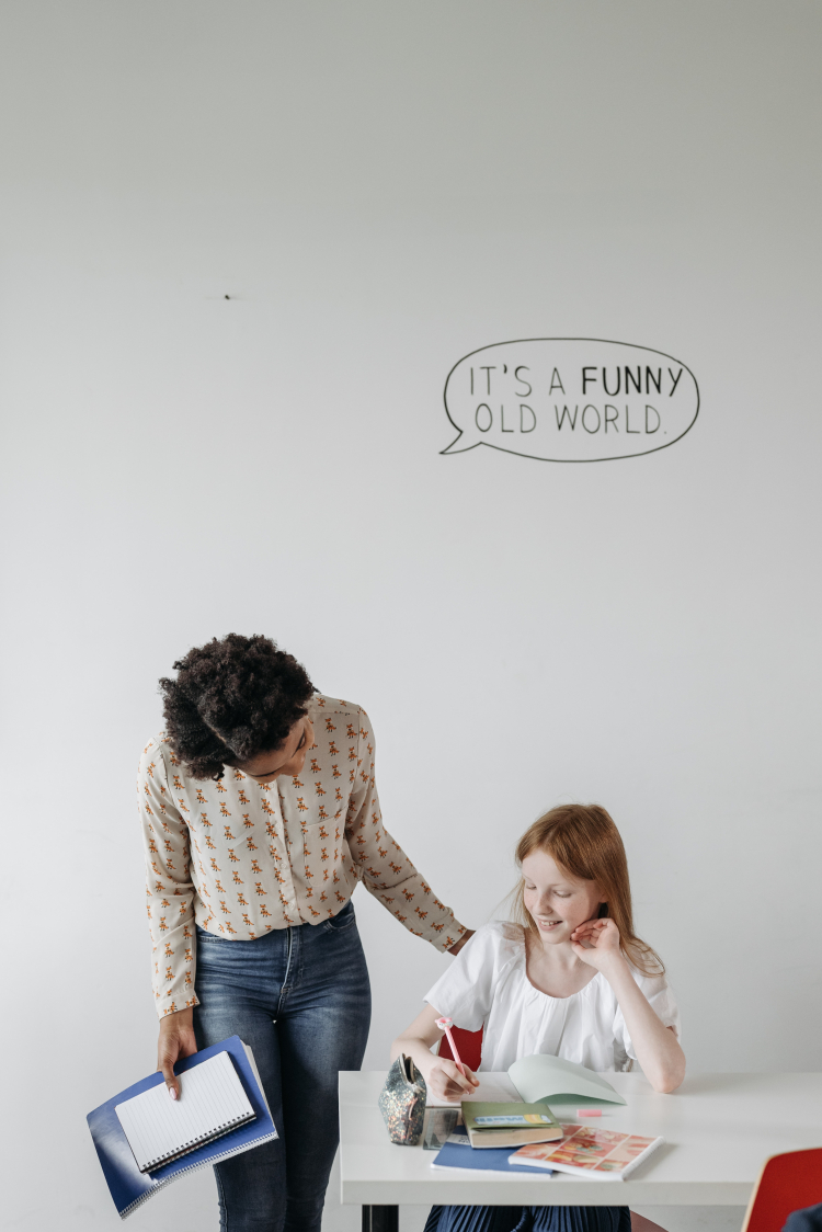 Imagem mostra uma mulher interagindo com uma garota.