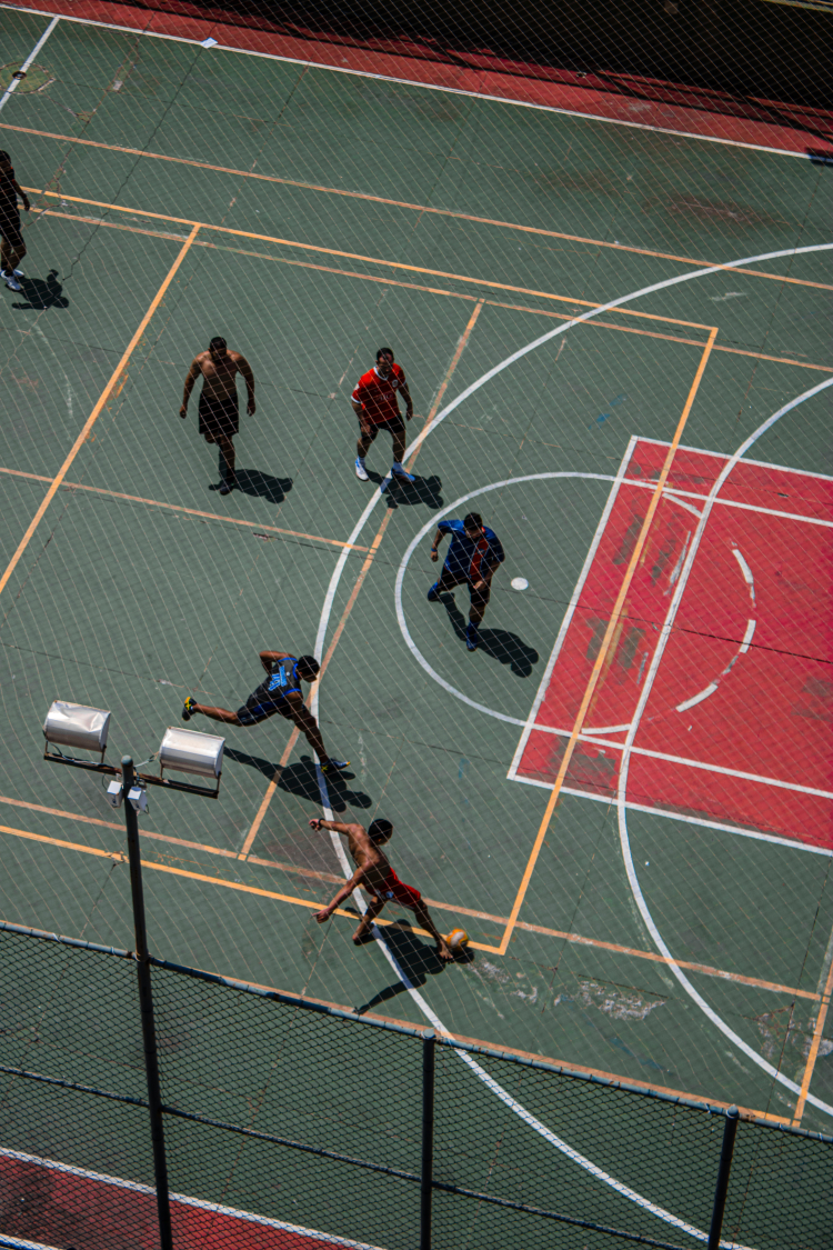 Imagem mostra cinco jogadores em uma quadra de futsal 