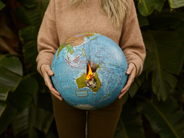 Imagem mostra uma pessoa segurando um globo representando o planeta terra
