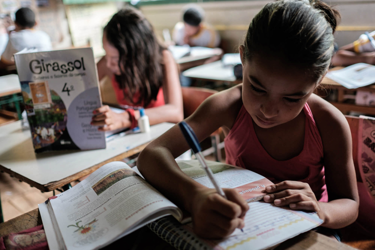 Uma sala de aula com crianças lendo e escrevendo